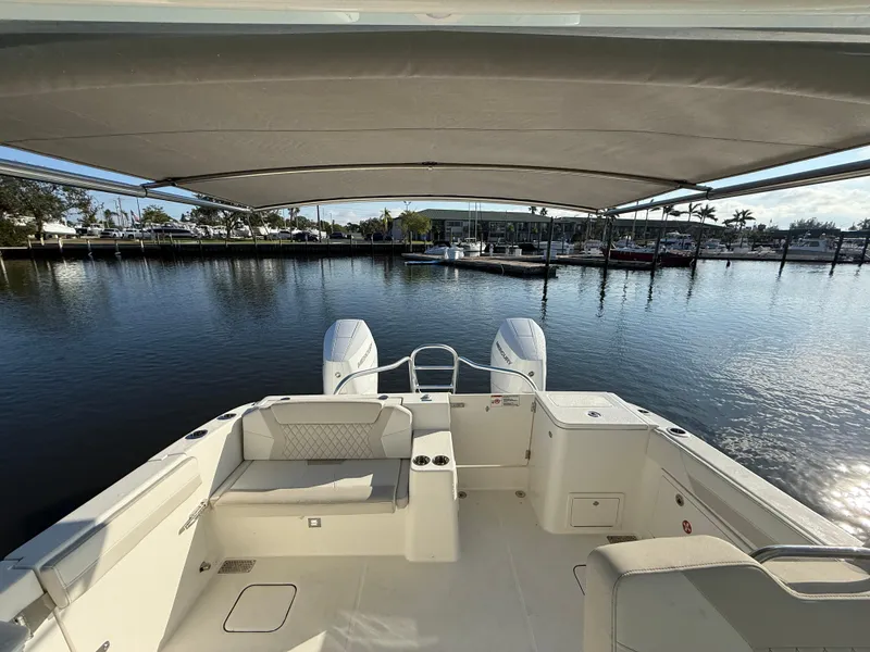 Slide: The Image of 2025 World Cat 325 DC boat with dual engines, docked under a canopy. - 33