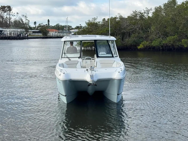 Slide: The Image of 2025 World Cat 325 DC boat cruising on a calm river. - 4