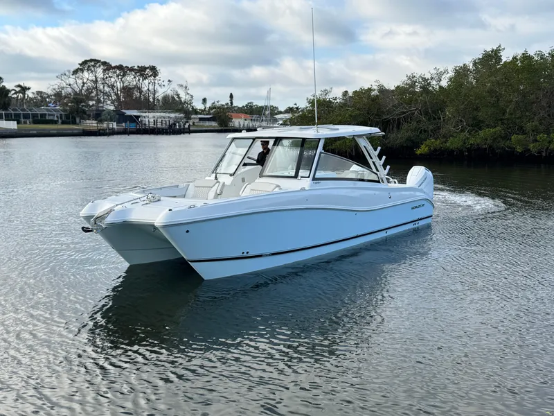 Slide: The Image of 2025 World Cat 325 DC boat cruising on a calm river. - 5