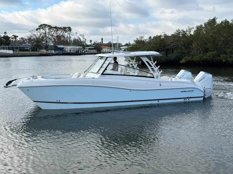 Slide: The Image of 2025 World Cat 325 DC boat cruising on a calm river. - 6