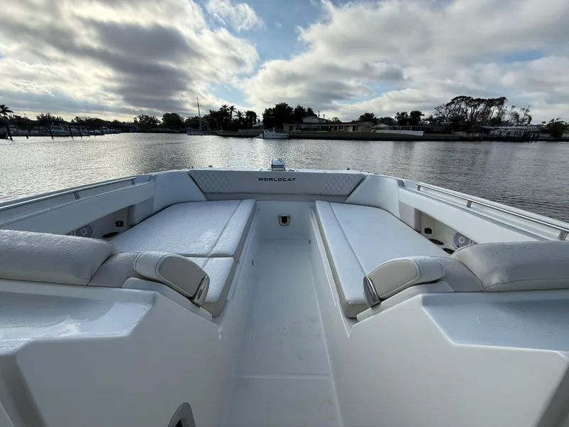 Slide: The Image of 2025 World Cat 325 DC boat interior with spacious seating on a calm lake. - 9