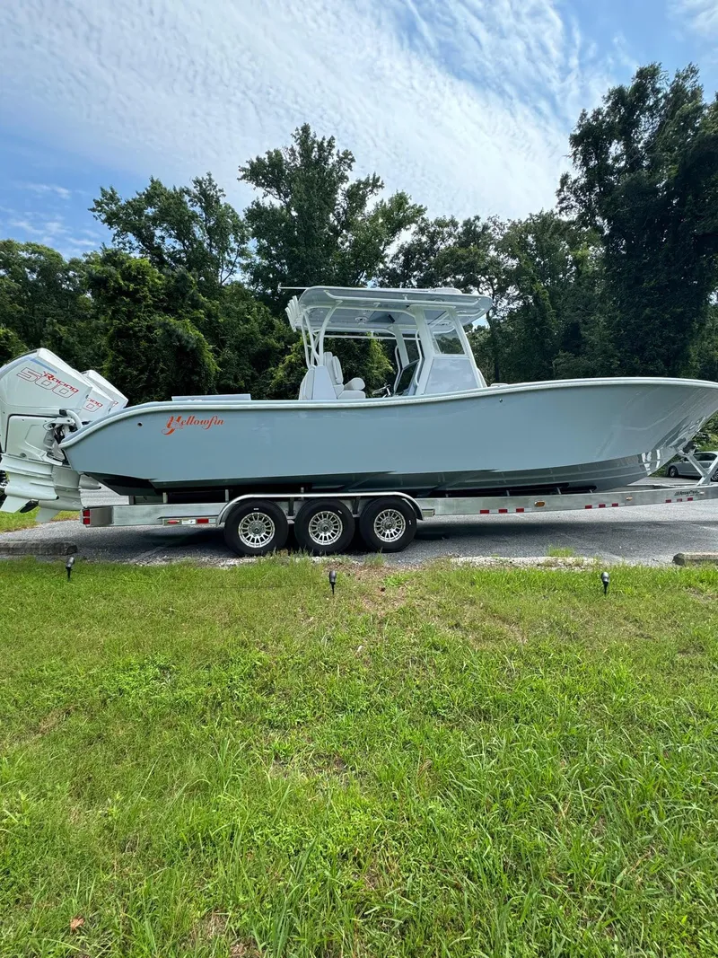 Slide: The Image of 2024 Yellowfin 36 Offshore boat on trailer, surrounded by greenery and trees. - 2
