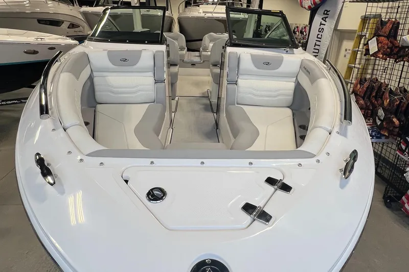 Slide: The Image of 2025 Regal LS4 boat interior with white and gray seating in showroom. - 16