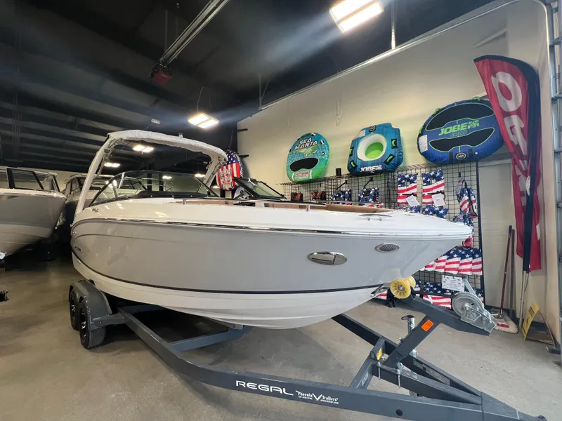 Slide: The Image of 2025 Regal LS4 boat displayed indoors on a trailer. - 1