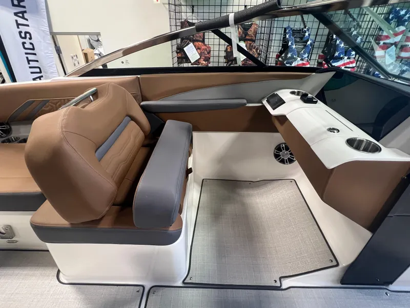 Slide: The Image of 2025 Regal LS4 boat interior with brown and gray seating, cup holders, and modern design. - 7