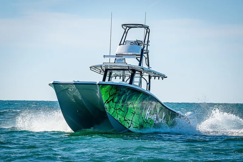 Slide: The Image of 2024 Costa Custom Boats 34 cruising on open water with vibrant green hull design. - 1