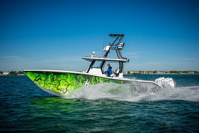 Slide: The Image of 2024 Costa Custom Boats 34 cruising on open water with vibrant green hull design. - 10