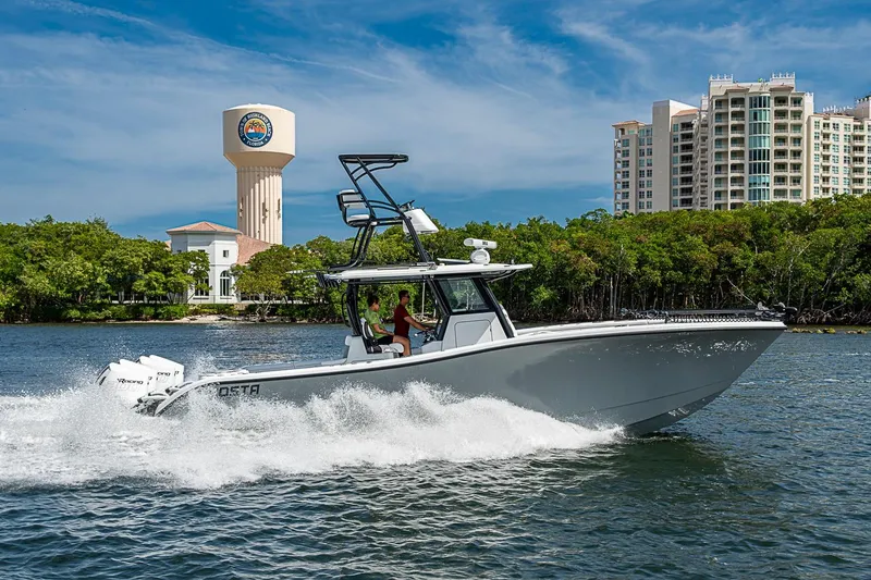 Slide: The Image of 2024 Costa Custom Boats 34 cruising on water near cityscape and water tower. - 107