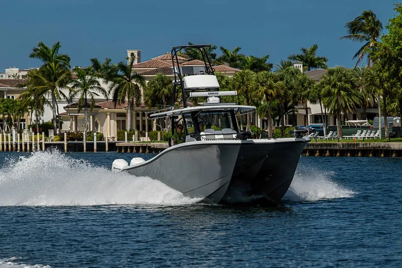 Slide: The Image of 2024 Costa Custom Boats 34 cruising on water near luxury waterfront homes. - 119