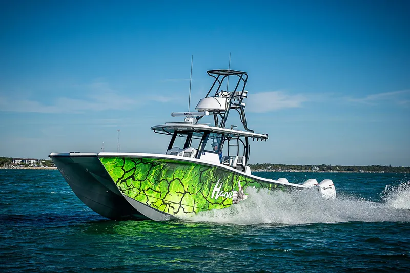 Slide: The Image of 2024 Costa Custom Boats 34 cruising on water with vibrant green hull design. - 13