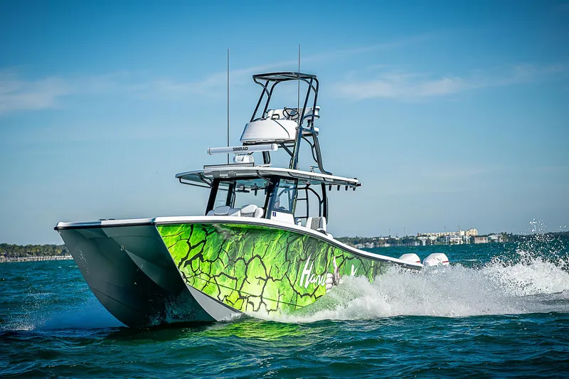 Slide: The Image of 2024 Costa Custom Boats 34 cruising on water with vibrant green hull design. - 14