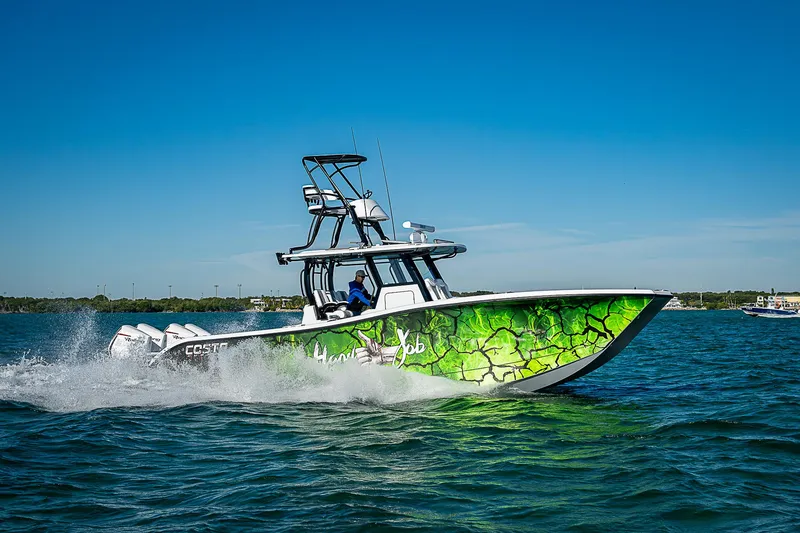 Slide: The Image of 2024 Costa Custom Boats 34 cruising on water with vibrant green hull design. - 16