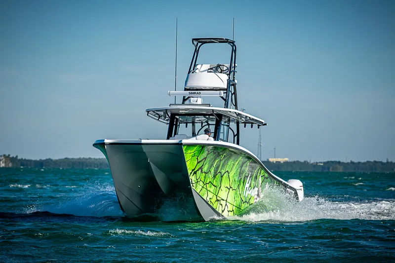 Slide: The Image of 2024 Costa Custom Boats 34 cruising on open water with vibrant green hull design. - 17