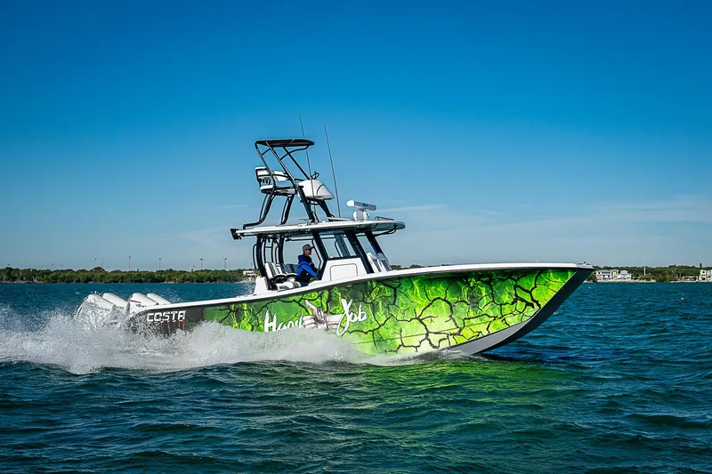 Slide: The Image of 2024 Costa Custom Boats 34 cruising on water with vibrant green hull design. - 18