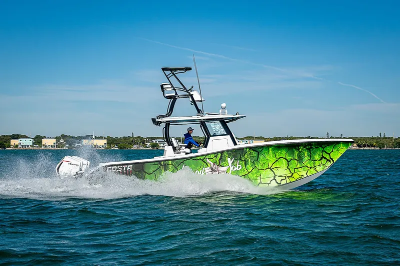 Slide: The Image of 2024 Costa Custom Boats 34 cruising on water with vibrant green hull design. - 20