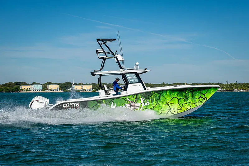 Slide: The Image of 2024 Costa Custom Boats 34 cruising on water with vibrant green hull design. - 21