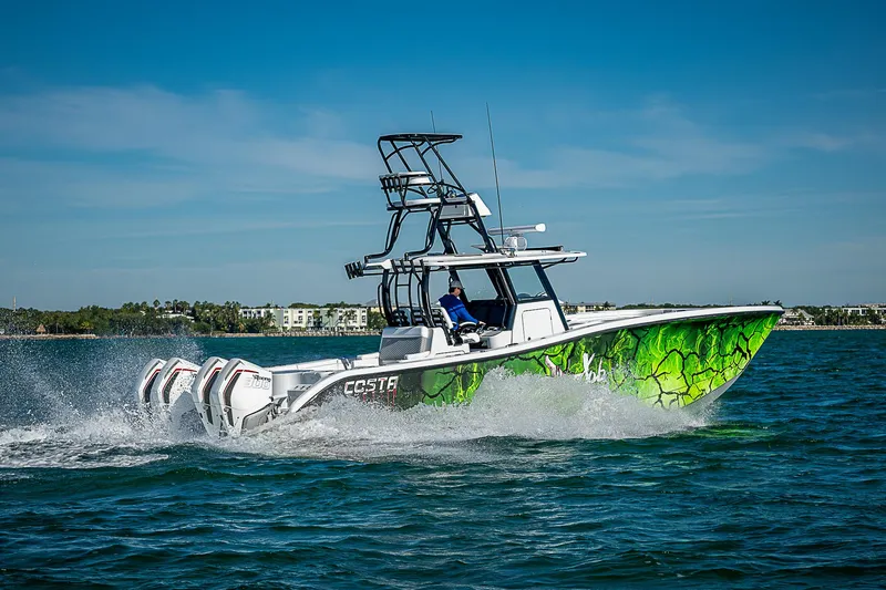 Slide: The Image of 2024 Costa Custom Boats 34 cruising on water with vibrant green hull design. - 26