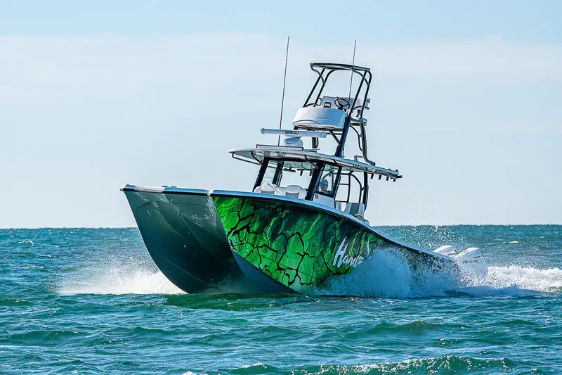 Slide: The Image of 2024 Costa Custom Boats 34 cruising on ocean with vibrant green hull design. - 3