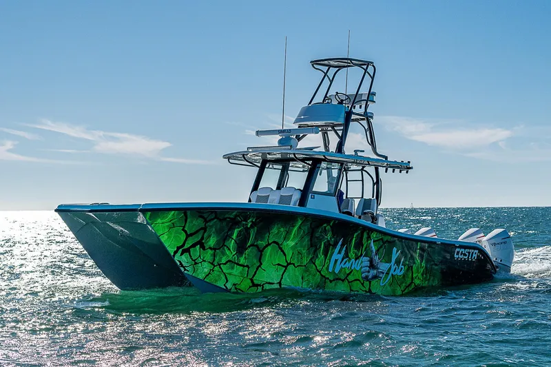 Slide: The Image of 2024 Costa Custom Boats 34 on water, vibrant green design, sunny day. - 36