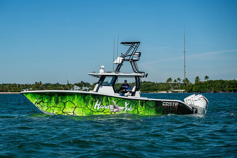 Slide: The Image of 2024 Costa Custom Boats 34 with vibrant green hull design on the water. - 40