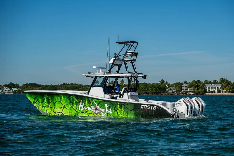 Slide: The Image of 2024 Costa Custom Boats 34 on water, vibrant green design, clear blue sky. - 41