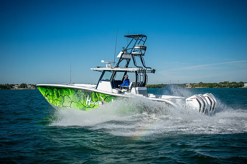 Slide: The Image of 2024 Costa Custom Boats 34 cruising on water, vibrant green hull design. - 7