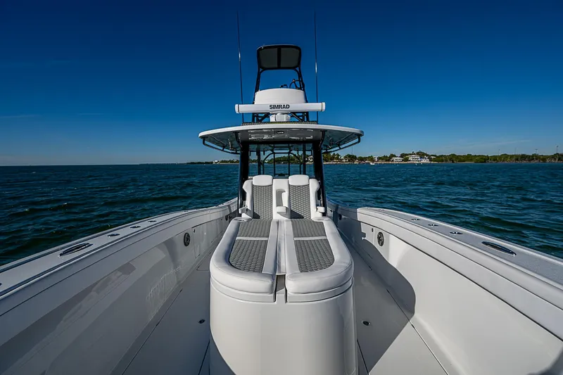 Slide: The Image of 2024 Costa Custom Boats 34 cruising on water near waterfront buildings and palm trees. - 100