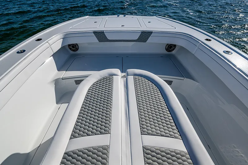 Slide: The Image of 2024 Costa Custom Boats 34 cruising on water with modern buildings in background. - 103