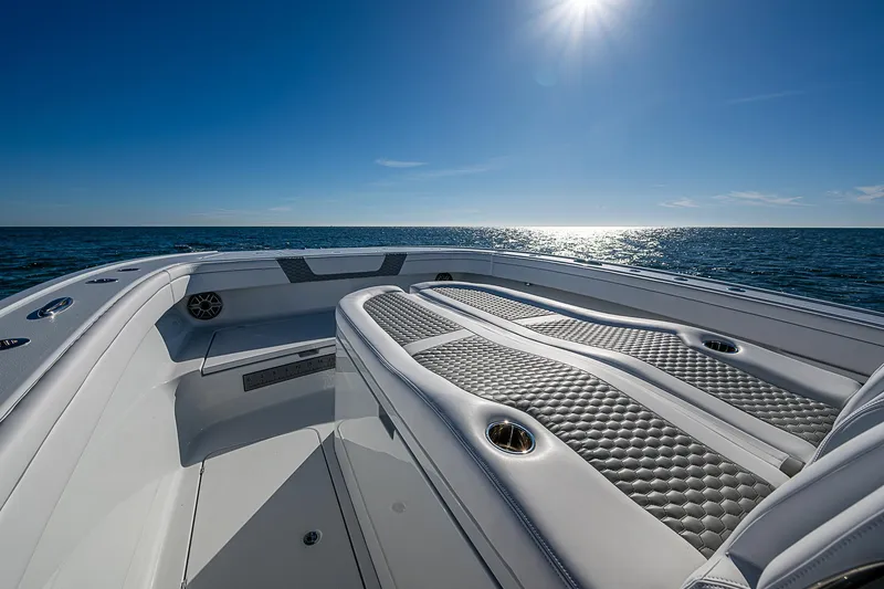 Slide: The Image of 2024 Costa Custom Boats 34 cruising near Boca Raton, Florida, with modern buildings in the background. - 104