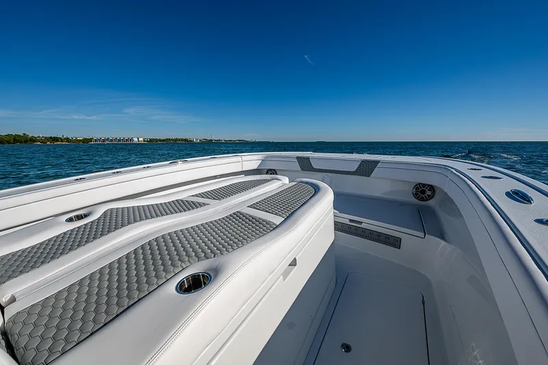 Slide: The Image of 2024 Costa Custom Boats 34 cruising on water near waterfront buildings and water tower. - 105