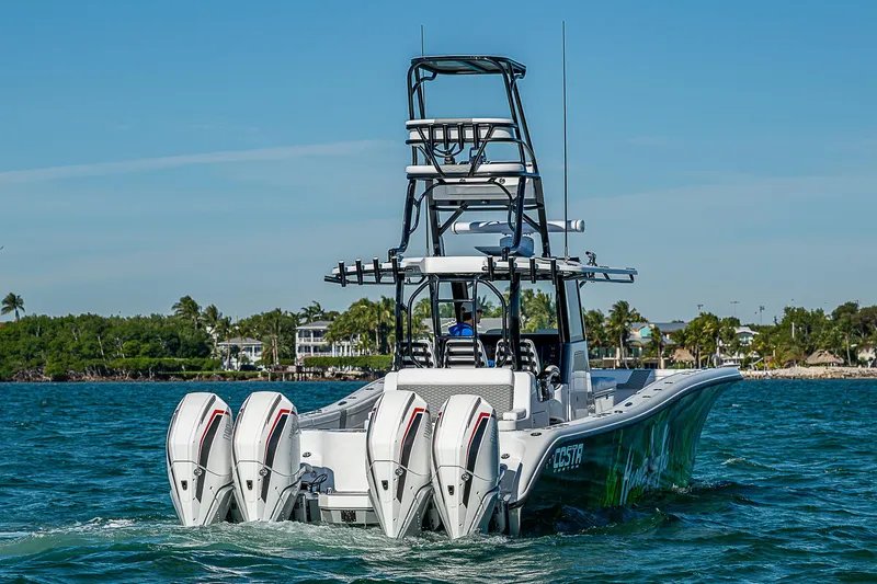 Slide: The Image of 2024 Costa Custom Boats 34 with quad engines on water, lush greenery background. - 46