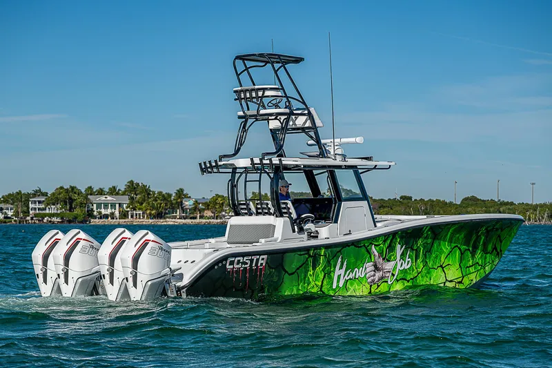 Slide: The Image of 2024 Costa Custom Boats 34 cruising on water with lush greenery background. - 47