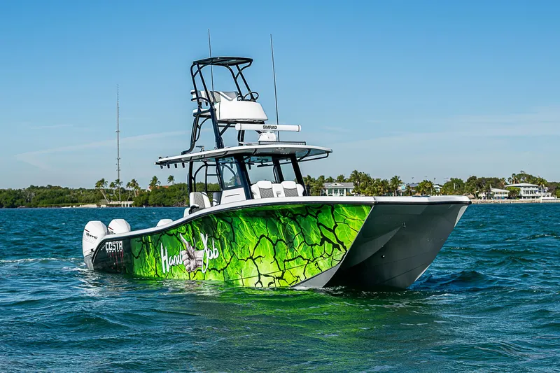 Slide: The Image of 2024 Costa Custom Boats 34 cruising on a scenic waterway with lush greenery. - 54