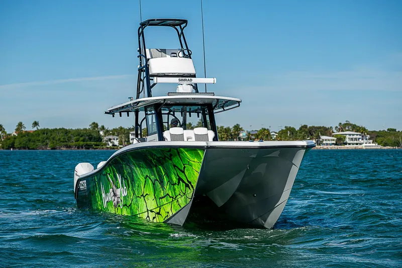 Slide: The Image of 2024 Costa Custom Boats 34 cruising on water with lush greenery in the background. - 55