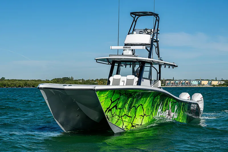 Slide: The Image of 2024 Costa Custom Boats 34 cruising on a scenic waterway with lush greenery. - 57