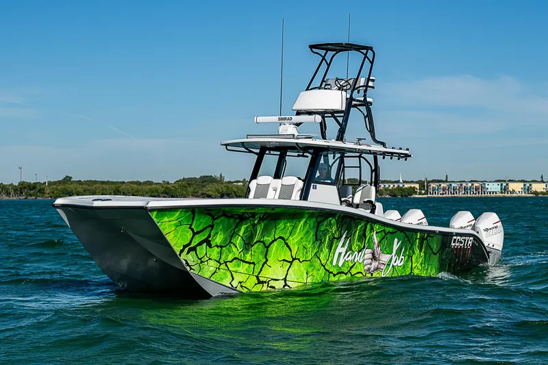 Slide: The Image of 2024 Costa Custom Boats 34 cruising on a scenic waterway with lush greenery. - 58