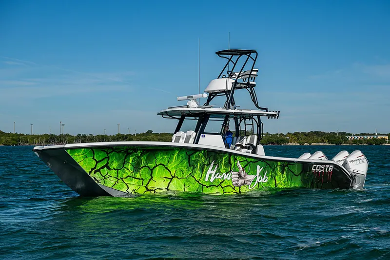 Slide: The Image of 2024 Costa Custom Boats 34 cruising on a scenic waterway with lush greenery. - 59