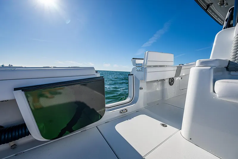 Slide: The Image of 2024 Costa Custom Boats 34 cruising on a scenic waterway with lush greenery. - 69