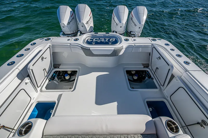 Slide: The Image of 2024 Costa Custom Boats 34 cruising on a scenic waterway near modern buildings. - 76