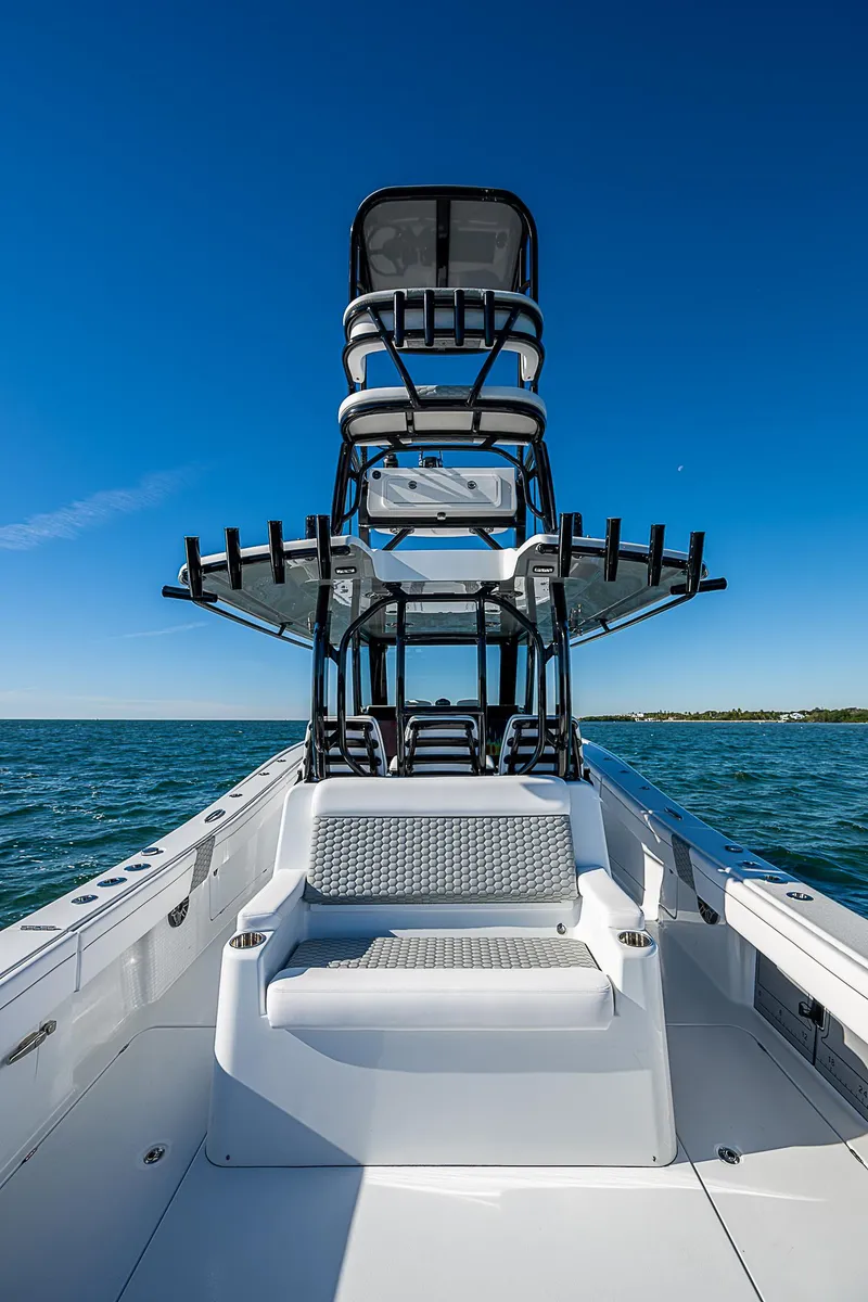 Slide: The Image of 2024 Costa Custom Boats 34 cruising on water near waterfront buildings and palm trees. - 77