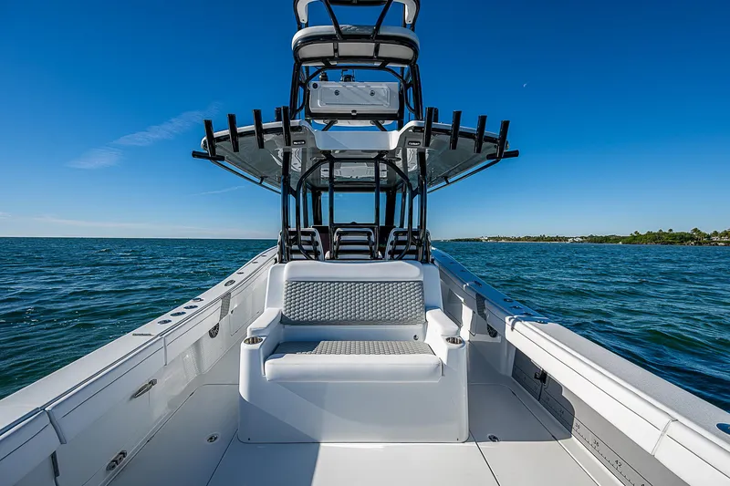Slide: The Image of 2024 Costa Custom Boats 34 cruising on a scenic waterway with lush greenery and buildings. - 79