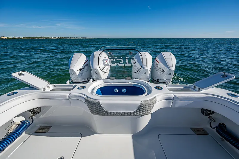 Slide: The Image of 2024 Costa Custom Boats 34 cruising on a scenic waterway with city backdrop. - 80