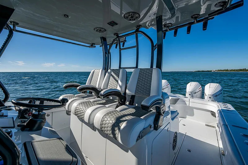 Slide: The Image of 2024 Costa Custom Boats 34 cruising on water near modern buildings. - 95