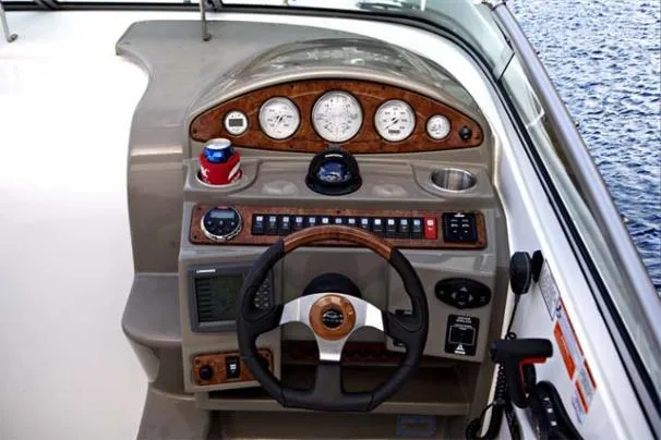 Slide: The Image of 2009 Rinker 260 Express Cruiser dashboard with steering wheel and control panel. - 10