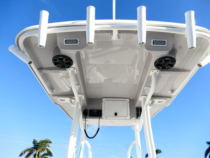 Slide: The Image of 2019 Sea Born LX22 Center Console T-top with rod holders and speakers against blue sky. - 10