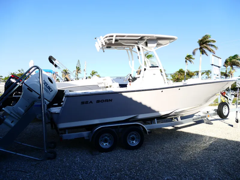 Slide: The Image of 2019 Sea Born LX22 Center Console boat on trailer, parked outdoors. - 2