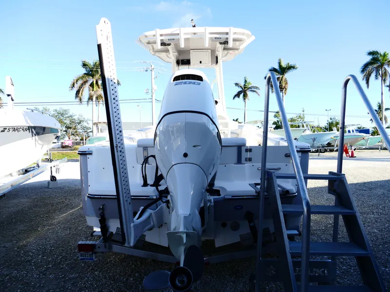 Slide: The Image of 2019 Sea Born LX22 Center Console boat with outboard motor, docked outdoors. - 3