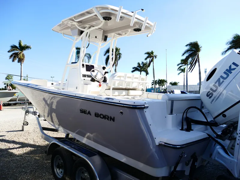 Slide: The Image of 2019 Sea Born LX22 Center Console boat with Suzuki engine, parked near palm trees. - 5