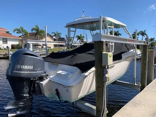 Slide: The Image of 2018 Key West 239 DFS boat with Yamaha engine on lift, docked by waterfront homes. - 0