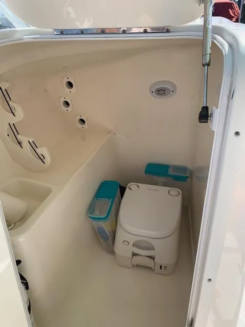 Slide: The Image of 2018 Key West 239 DFS boat interior with portable toilet and storage compartments. - 15